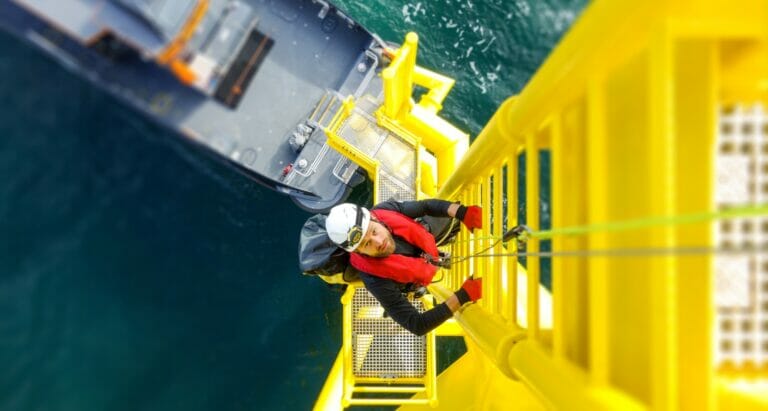 Technician inspecting lifting equipment on an offshore wind turbine