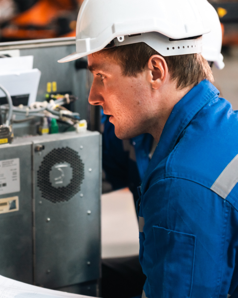Engineer inspecting electrical equipment inside a machine control panel for EN 60204-1 verification